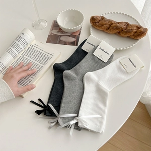 Close-up of combed cotton socks with vertical stripes and delicate ribbon bows