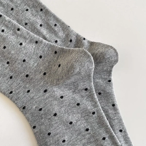 Detailaufnahme grauer Strick-Socken mit schwarzen Punkten und feiner Textur