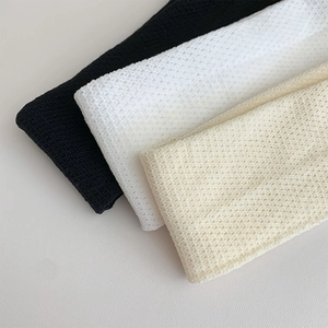 Close-up of white, beige, and black knit hollow mesh textures of calf socks