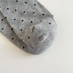 Nahaufnahme grauer gepunkteter Socken mit nahtloser Zehen- und Fersenverarbeitung