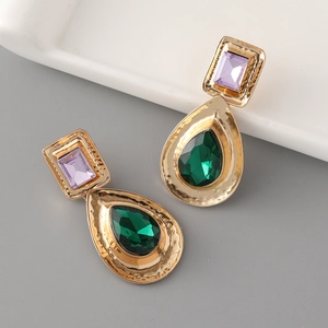 Macro detail of teardrop emerald crystal earrings with vintage gold settings