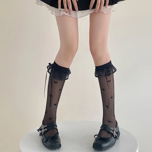Detailed view of sheer black calf socks with lace trim, bows, and flocked hearts
