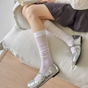 Detailed close-up of white mesh calf socks paired with silver Mary Jane shoes and a skirt