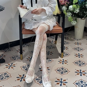Vue détaillée de chaussettes hautes en dentelle blanche avec motifs floraux vintage