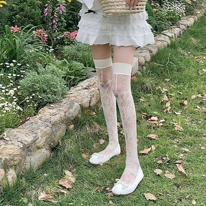 Détail de chaussettes hautes blanches en dentelle florale avec bord élastique doux