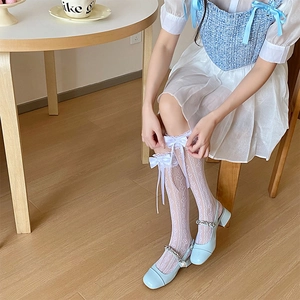 Detail of white heart mesh lace socks with bows paired with blue Mary Jane shoes