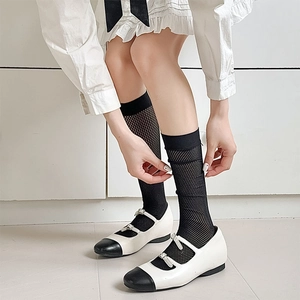 Detail of breathable black mesh calf socks with ribbed cuffs and vintage Mary Jane shoes