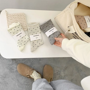 Detailansicht beige und graue Polka-Dot-Baumwollsocken in weicher Markenverpackung