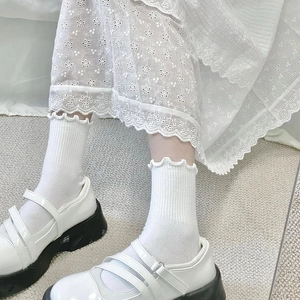 Gros plan de chaussettes blanches à froufrous avec texture côtelée et chaussures Mary Jane