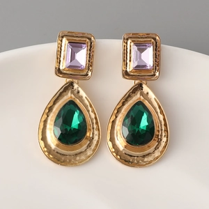 Vintage gold earrings with emerald green teardrop crystals and purple stones in retro style