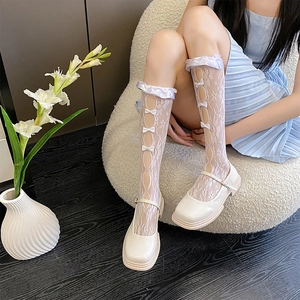 Detail of white lace knee high socks featuring floral mesh and cute bow embellishments
