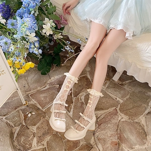 Detail of cream Mary Jane shoes with bows and white lace mesh hollow knee high socks