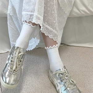 Baskets métallisées argentées avec chaussettes à volants et détail de jupe en dentelle