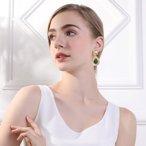 Close-up of model wearing vintage water-drop emerald crystal earrings with gold plating