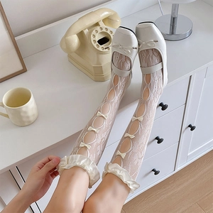 Detail view of lace calf socks featuring white satin bows and elegant frilled ruffles