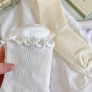 Détail de chaussettes à bord volanté avec texture tricotée en blanc et beige
