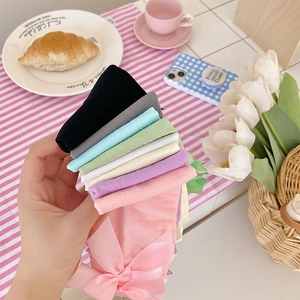 Close-up of colorful velvet socks with satin bows in pastel shades for Lolita style