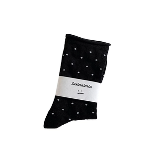 Japanische schwarze gepunktete Socken mit weißer Verpackung auf weißem Hintergrund