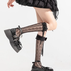 Detail of black lace calf socks with hollow heart patterns and satin ribbon bows