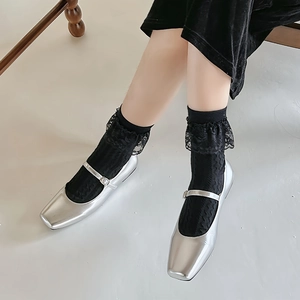 Scarpe Mary Jane argento con punta quadrata e cinturino indossate con calze di pizzo nero