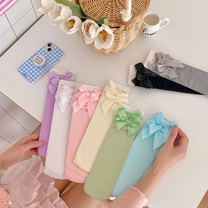 Detail of sweet Lolita velvet socks with satin bow accents in various pastel candy colors