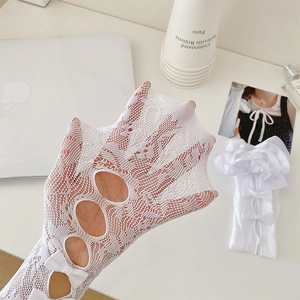 Detail of white lace stockings with bow accent and delicate cutout mesh texture