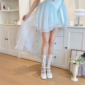 Detail of white lolita knee-high socks with bows and rhinestones on mary jane shoes
