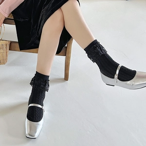 Dettaglio calzini neri con pizzo abbinati a scarpe Mary Jane argento metallizzato