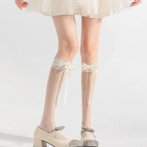 Detail of cream lace stockings with bow accents and breathable heart mesh pattern