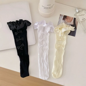 Detail of sweet lace mesh calf socks with ruffled edges and delicate bow accents