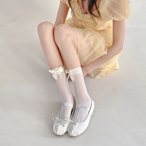 Detail of white semi-transparent Lolita socks featuring a delicate satin bow decoration
