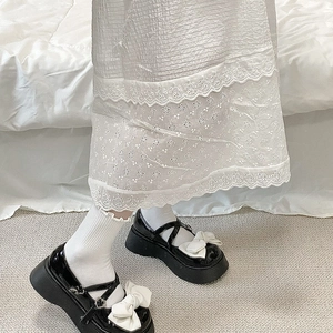 Détail de chaussures Mary Jane noires à plateforme avec nœud blanc et chaussettes à froufrous