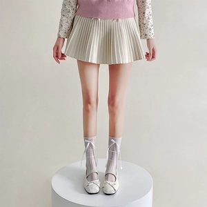 Detail of white mesh lolita knee socks with bow accents paired with Mary Jane shoes