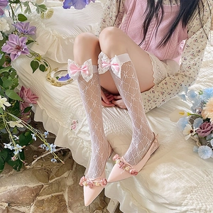 Close-up of white mesh lace socks with pink bows paired with flower flat shoes