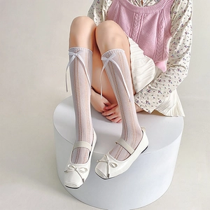Detail of white mesh lolita calf socks with ribbon bows and Mary Jane shoes