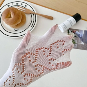 Close-up of white Lolita mesh socks with heart patterns and lace hollow knitting texture