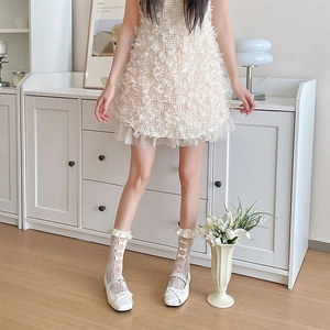Close-up of white lace calf socks featuring delicate ribbon bows and frilled ruffle edges