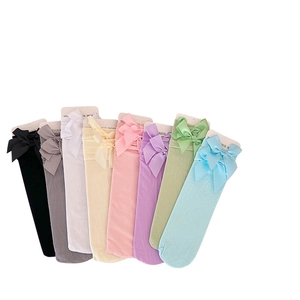 Eight pairs of colorful velvet crew socks with large silk bows in various pastel shades