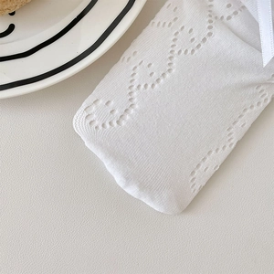 Detail of white hollow-out knit calf socks with a delicate silk bow in Lolita style