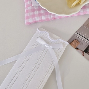 Detail of white pointelle calf socks with satin bow and delicate ruffled edges