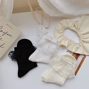 Detailed view of three pairs of vertical striped socks with sweet lace trim in white, black, beige