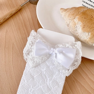 Detailed view of white lace baby socks featuring satin bows and mesh knit pattern