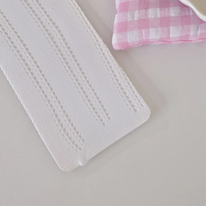 Detailed macro view of white lace knitted fabric with delicate openwork stripe pattern