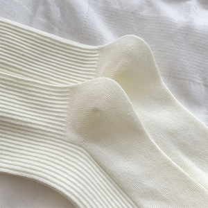 Nahaufnahme der cremeweißen Rippstrick-Textur und verstärkten Ferse an süßen Ballettsocken