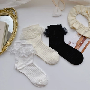 Detailed view of three pairs of vertical stripe lace socks in white and black colors