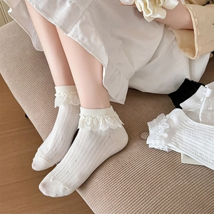 Détail de chaussettes blanches Lolita en dentelle avec maille ajourée et bords volantés