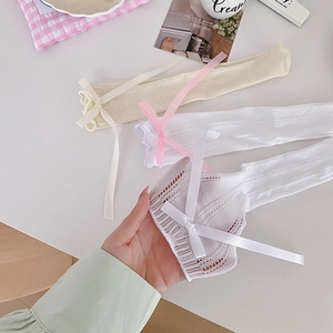 Close-up of thin mesh lace socks with silk bow detail and breathable hollow texture