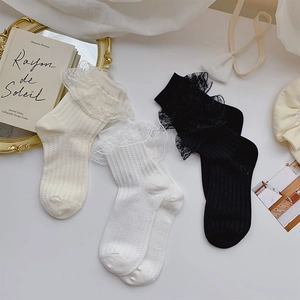 Detailed close-up of lace-trimmed crew socks in ivory, white, and black with vertical stripes