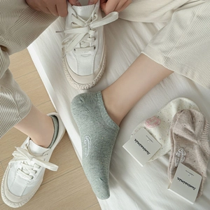 Close-up of combed cotton ankle socks with colorful flecks and embroidered details