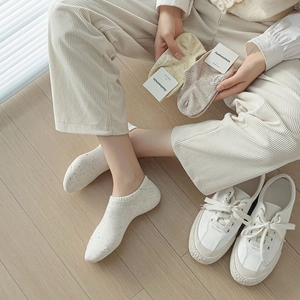 Close-up of breathable cotton low-cut socks in beige and light yellow on wooden floor